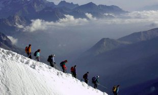 Climbers walk down the Aiguille du Midi, below Mont Blanc, in the French Alps